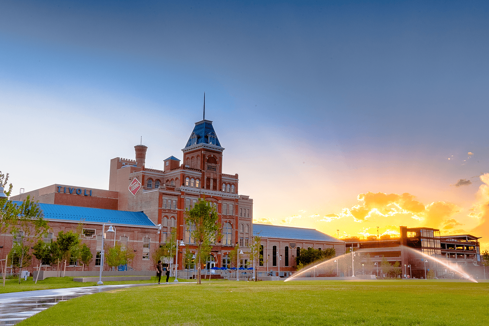 Tivoli Student Union building at sunset with sprinklers running