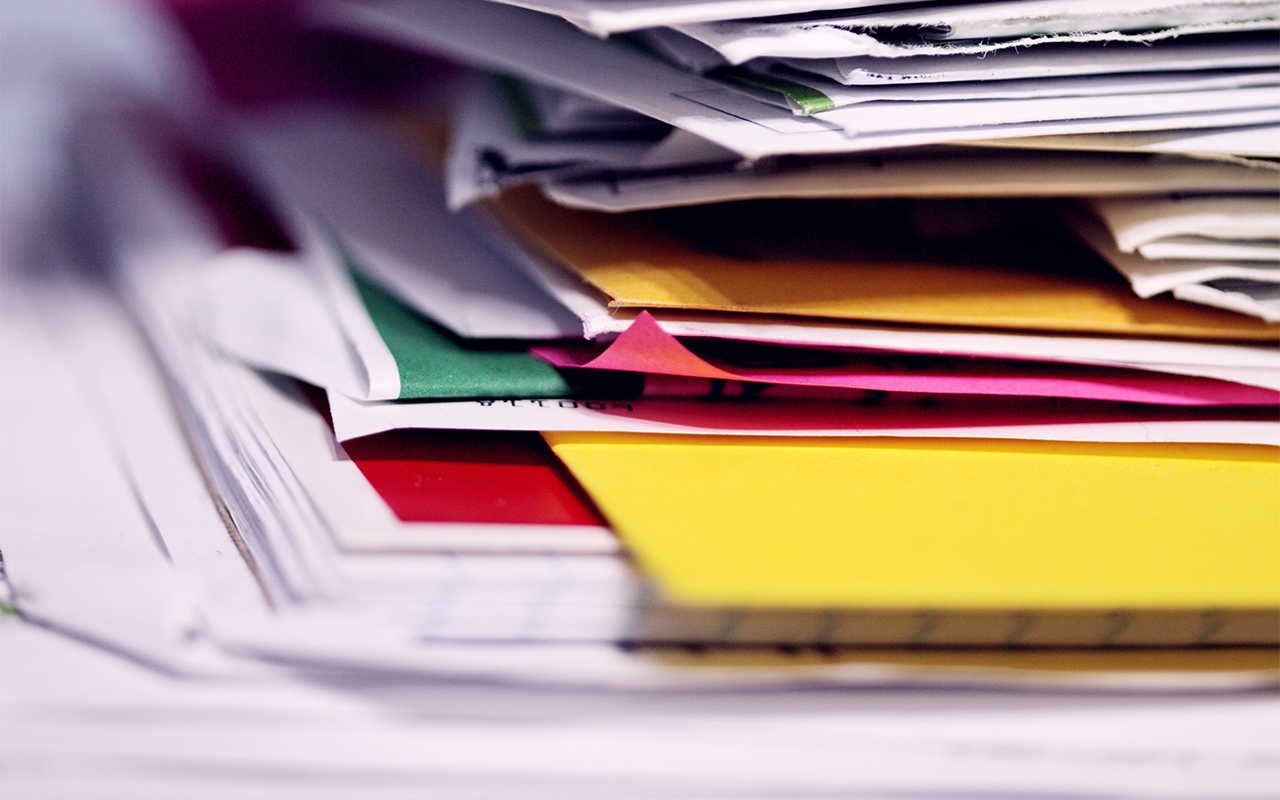 A stack of paper and brightly colored folders