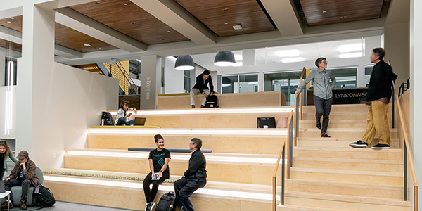 Students sitting on bench inside Student Commons Building