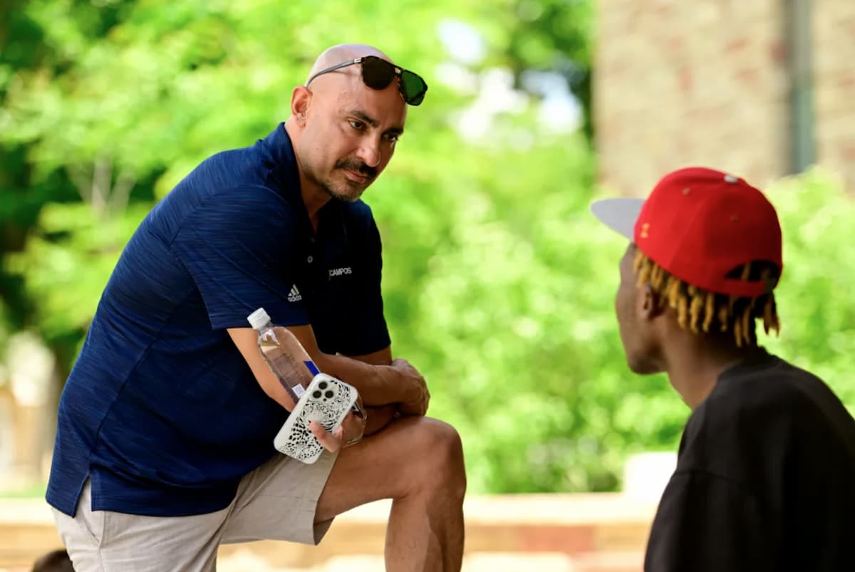 Marco Campos outside speaking with a student.