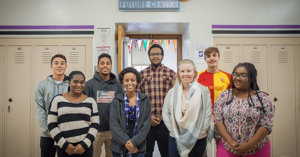 A group of eight educators standing outside of a classroom.