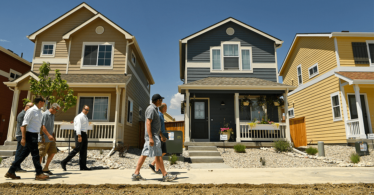 People walking down a new Denver housing development.