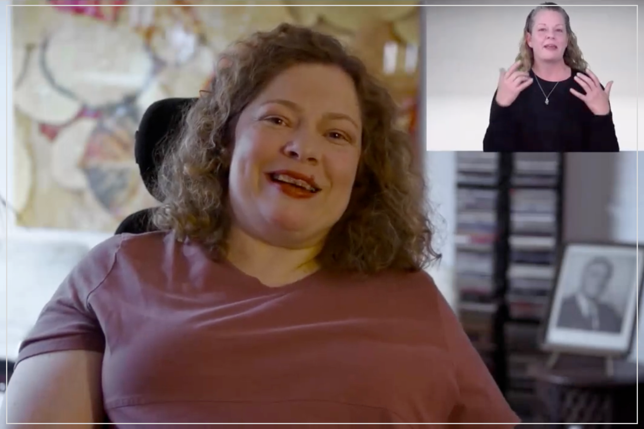 A woman in a wheelchair speaks while an interpreter signs